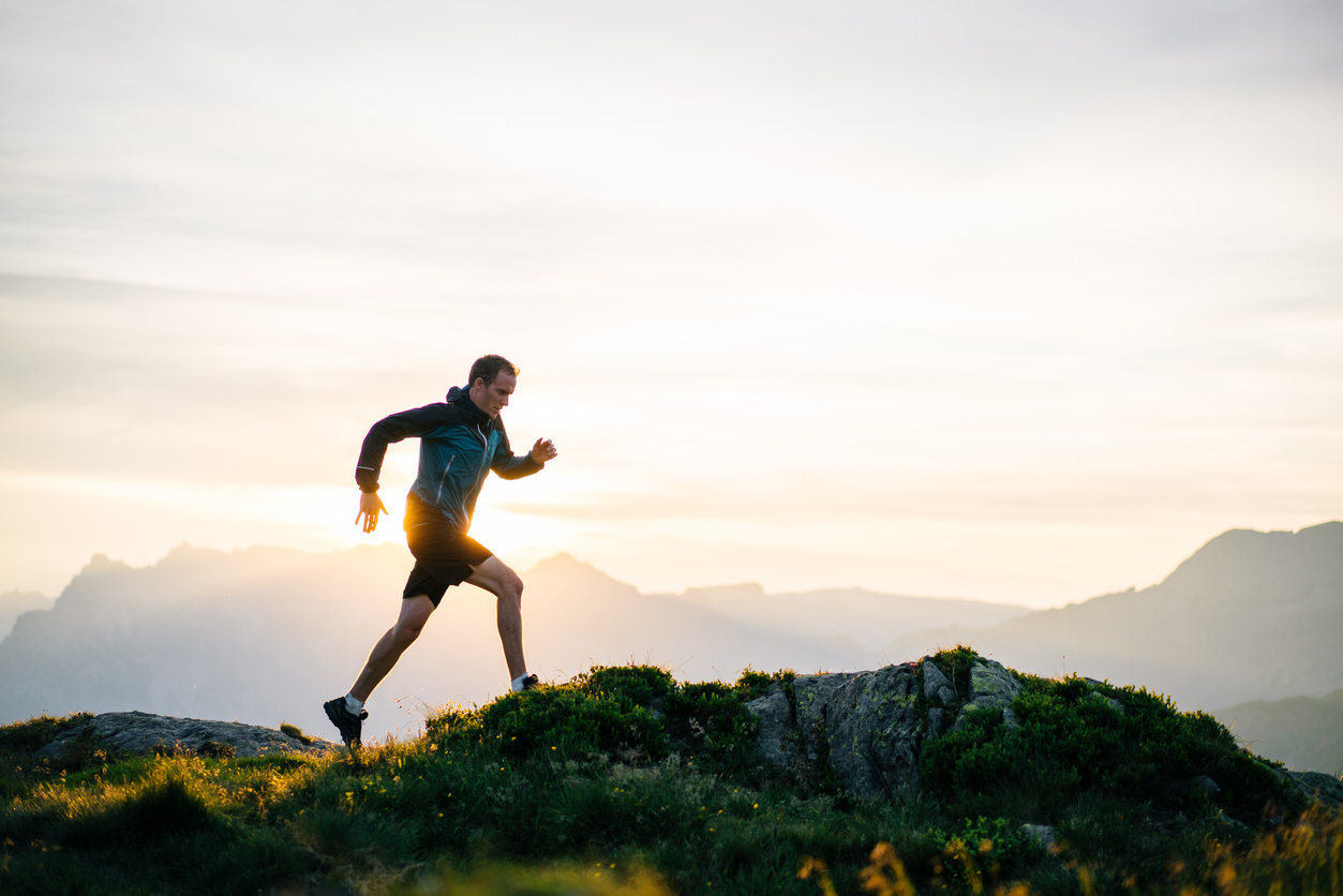 Jogger op heuvel bij zonsopgang